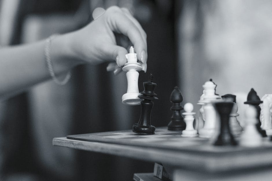 Black and white image capturing a strategic chess move with a wooden chessboard in Eskişehir.