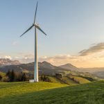 The Renewable Energy Paradox: Literary Lessons for Strategic Leaders Peaceful countryside with wind turbines during sunset, showcasing sustainable energy.