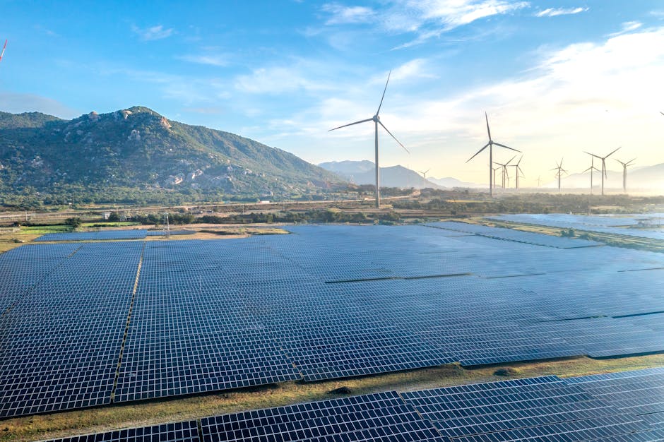 Aerial view of a solar and wind energy farm set against Vietnam's scenic landscape.
