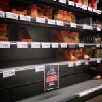 Half empty shelves with assorted products in jars and containers in supermarket during quarantine