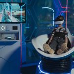 <h1>The Simulation-to-Reality Programmable Biology Compiler: The Future of Cybersecurity</h1> A child immersed in a futuristic virtual reality game with neon lights and advanced technology.