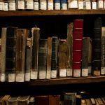 Old and rare books on wooden shelves in a São Paulo library, showcasing classic literature and history.