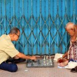 The Strategic Advantage of Aging Ethics in Corporate Leadership Two elderly men enjoy a strategic game of chess on the streets of Jambi, Indonesia.