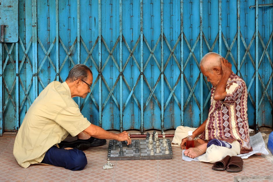 Two elderly men enjoy a strategic game of chess on the streets of Jambi, Indonesia.