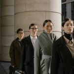 The Strategic Aesthetics: How Fashion Shapes Executive Presence Group of professional women in elegant business attire posing outdoors in urban setting.
