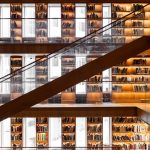 Striking view of a multi-level library with wooden bookshelves and warm lighting in İstanbul.