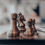 A detailed close-up of chess pieces on a board, highlighting the knight in warm tones.