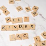 The Strategic Edge: How Multilingualism Shapes Artistic Innovation Scrabble tiles forming the words 'Welt Kinder Tag' on a marble background, symbolizing children's day.