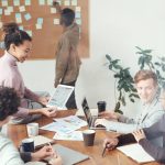 A diverse group of professionals discussing ideas in a modern office setting. Perfect for business and teamwork concepts.
