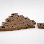 Wooden Scrabble tiles spelling 'IMAGINATION' arranged on a white background.
