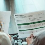 The Strategic ROI of Mental Health in Leadership and Operations Close-up of two individuals analyzing financial documents related to return on investment.
