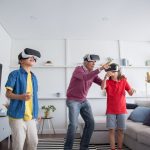 Grandfather and grandchildren bonding over VR gaming in a modern living room.