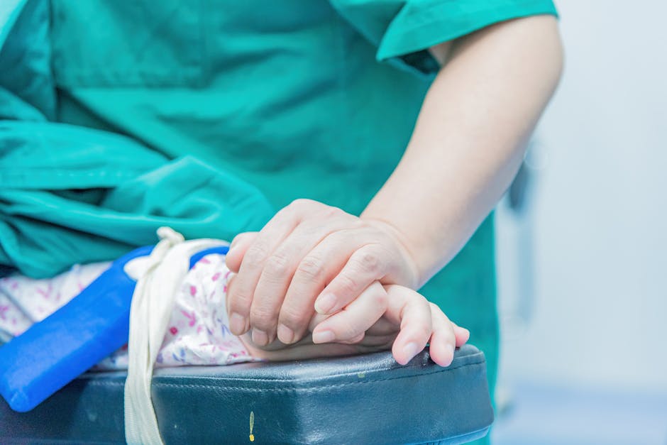 Medical professional comforting a patient by holding hands in an operating room setting.