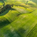 Aerial view of vibrant green fields showcasing a peaceful countryside landscape.