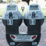 Photo of two parking meters in Orlando showing coin and card payment options on a brick road.