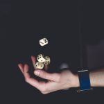 <h1>Uncertainty-Quantified Emergent Behavior Theory for Robotics</h1> A close-up of a hand tossing several dice against a dark background, symbolizing chance and luck.
