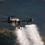 Uncertainty-Quantified Fertilizers for Autonomous Agriculture Drone dispersing spray over farmland, showcasing modern agriculture techniques.