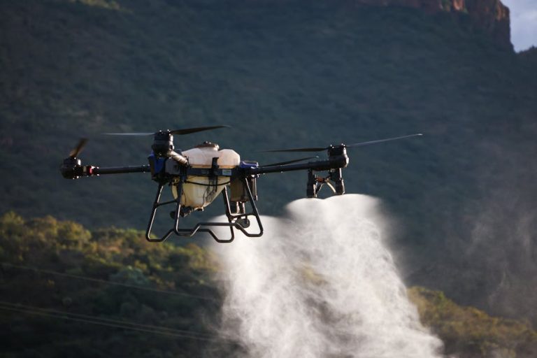 Drone dispersing spray over farmland, showcasing modern agriculture techniques.