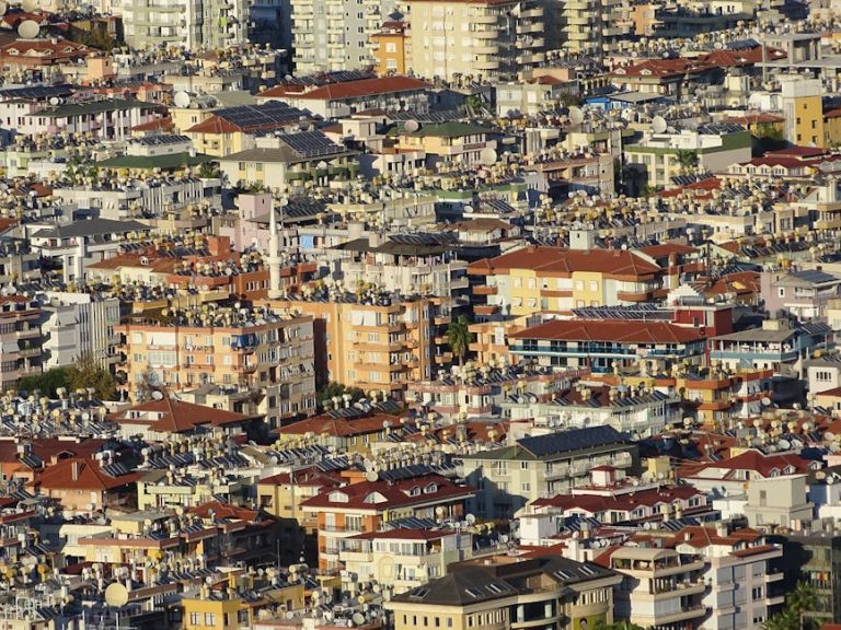 A dense urban landscape in Alanya, Turkey, showcasing residential buildings with orange rooftops.