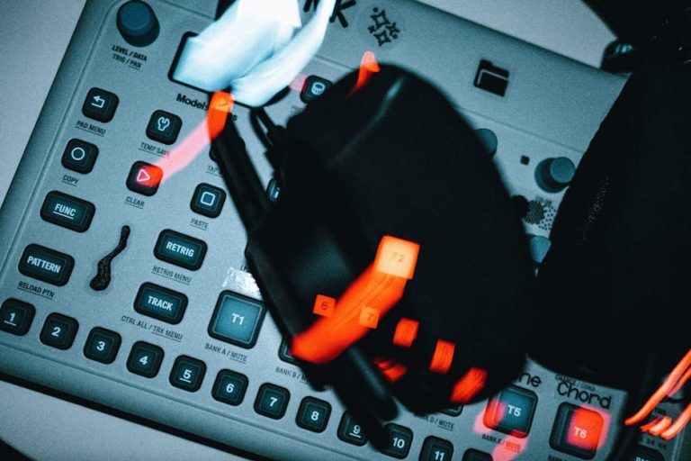 Blurred dynamic shot of buttons and controls on modern music production equipment with glowing lights.