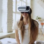 Virtual Reality in Finance: Beyond the Hype to Strategic Execution Woman enjoying virtual reality experience at home, smiling and relaxed.