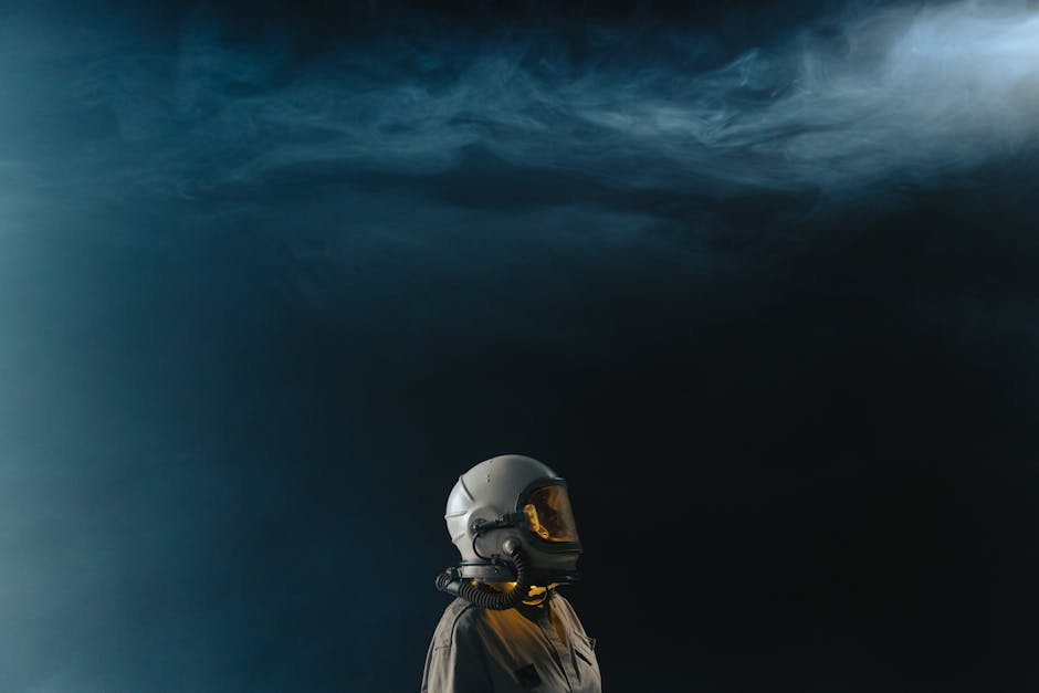 Astronaut in a helmet looks toward the stars in a mysterious space setting.