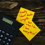 Funny sticky notes about cryptocurrency trading with calculator on wooden table.
