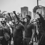 Why History Demands Empathy for Strategic Leadership A powerful image of protesters raising fists during a Black Lives Matter rally in an urban setting.