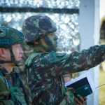 Why Leadership is the Ultimate Operating System for Technology Soldiers in camouflage and helmets strategizing outdoors, focusing on a mission directive.