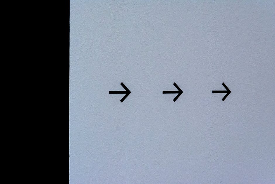 Simple white wall featuring three black arrows pointing right, conveying direction.
