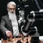 Zero-Shot Embodied Intelligence Simulators for Urban Planning An older man engages in a strategic chess game with a robotic arm, illustrating the blend of tradition and technology.