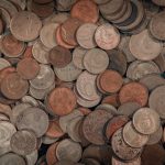 Close-up view of assorted foreign coins in a large mixed pile, perfect for finance-related projects.