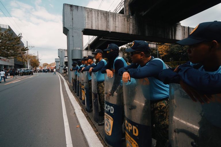 Row of police officers in uniform guarding a street during a demonstration.