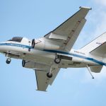 NASA aircraft in flight showcasing engineering marvel against a clear blue sky.