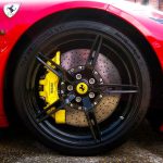 Detailed shot of Ferrari's alloy wheel and tire, showcasing performance brake caliper.