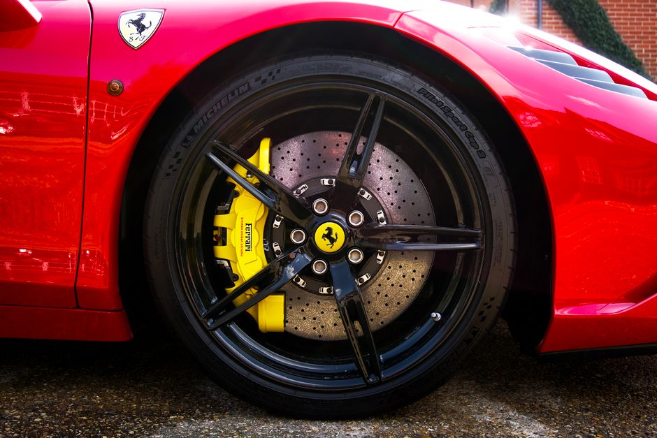 Detailed shot of Ferrari's alloy wheel and tire, showcasing performance brake caliper.