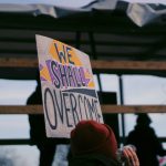 Algorithmic Justice: Overcoming Bias in AI Decision Systems Protesters holding a 'We Shall Overcome' sign during a rally in Berlin, Germany.