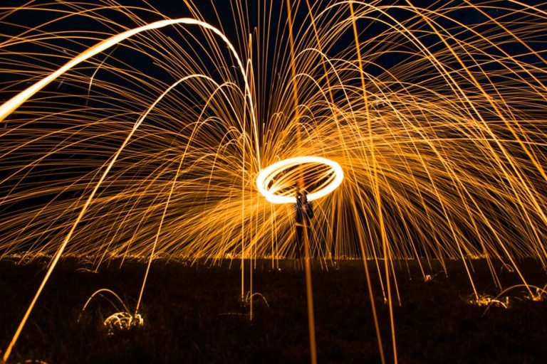 Captivating steel wool photography showcases vibrant spark trails and motion at night.