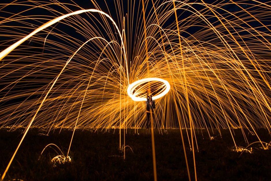 Captivating steel wool photography showcases vibrant spark trails and motion at night.