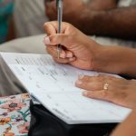 A woman writing in a calendar planner, highlighting organization and time management.