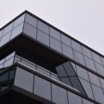 Architecting Emergence: How to Build High-Performance Systems A striking modern building in Amsterdam with a reflective glass facade showcasing sleek architectural design.