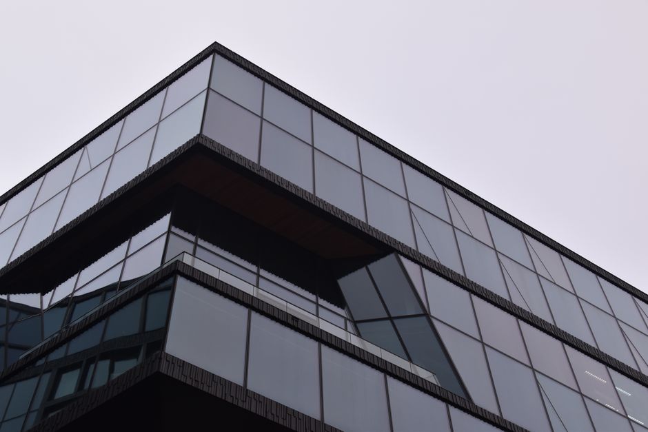 A striking modern building in Amsterdam with a reflective glass facade showcasing sleek architectural design.