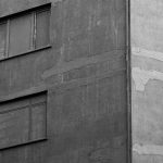 Black and white photo of a building facade showing texture and architecture details.