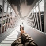 POV shot of legs sliding down a chute, creating a thrilling sense of motion.