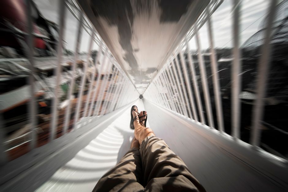POV shot of legs sliding down a chute, creating a thrilling sense of motion.