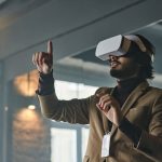Businessman engaging with virtual reality technology indoors, pointing finger.