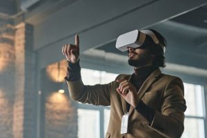 Businessman engaging with virtual reality technology indoors, pointing finger.