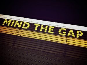 Bold 'Mind the Gap' text on a subway platform, emphasizing passenger safety.