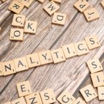 Bayesian Predictive Modeling for Elite Strategic Decision-Making Scrabble tiles spelling 'Analytics' on a wooden surface, symbolizing data analytics concept.