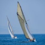 Two classic sailboats glide gracefully on blue ocean waters during a sunny day, showcasing maritime elegance.